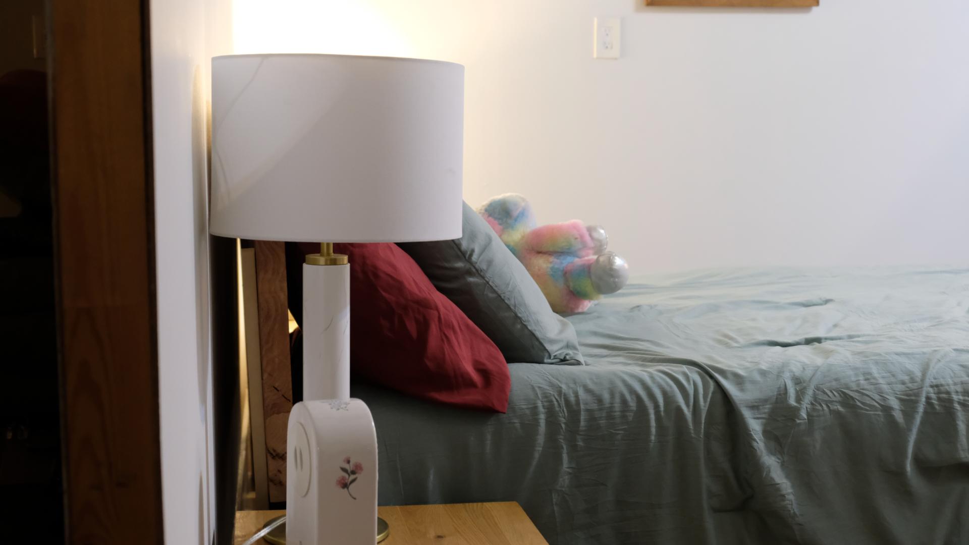 Bedroom film set with a neatly made bed, soft lighting, and minimal décor prepared for a scene shoot