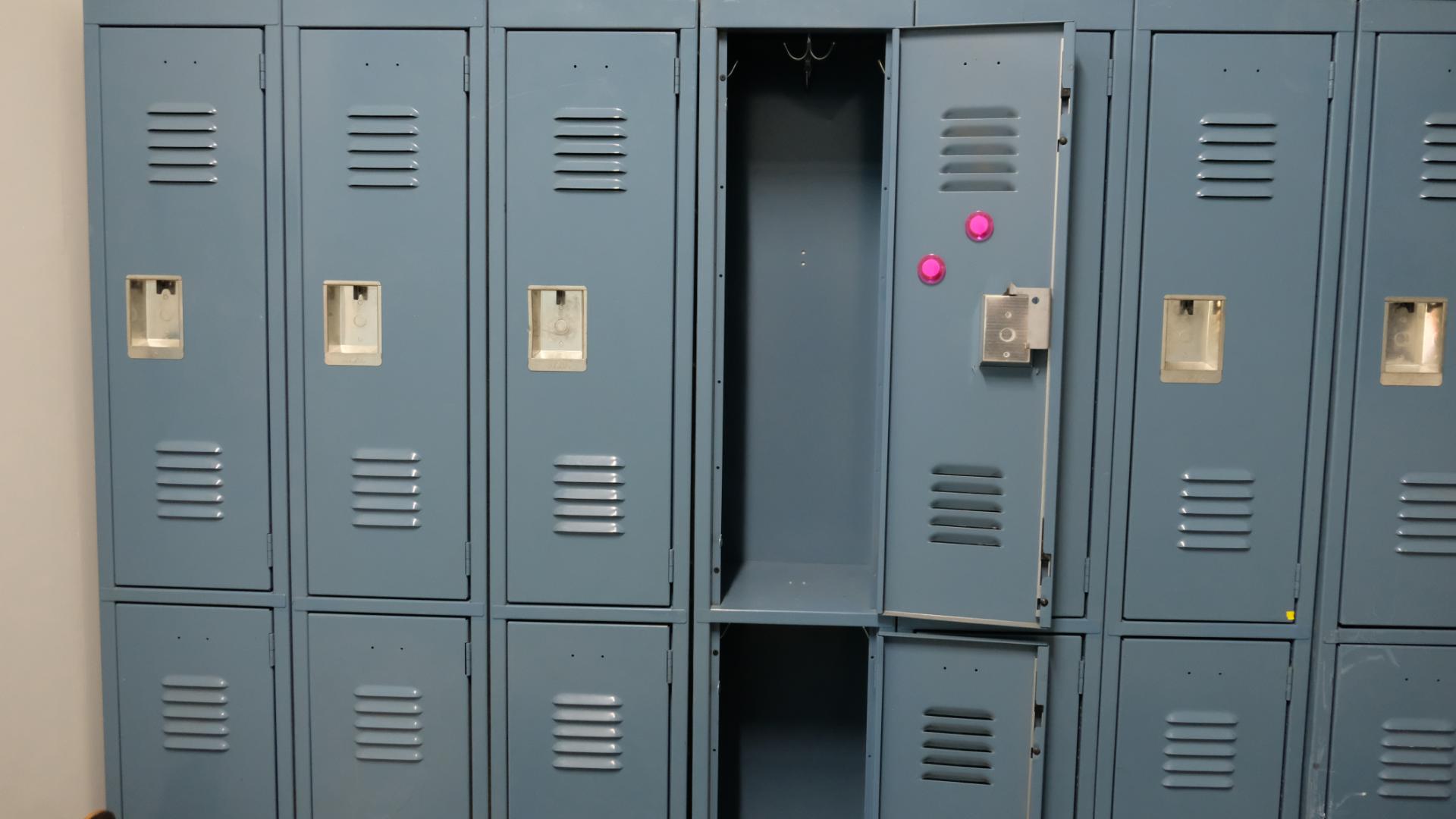 High school locker hallway film set with long perspective, fluorescent lighting, and dramatic depth.”